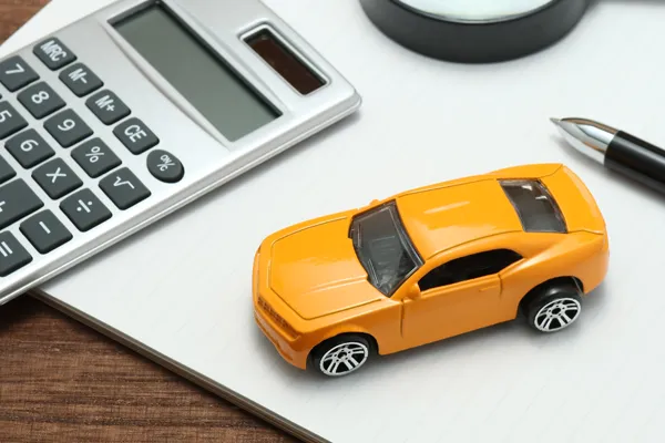 A photo of a toy car and a calculator