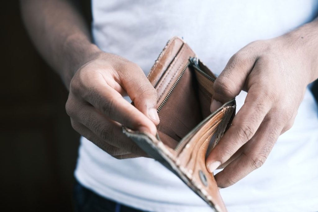 a man with no money in his wallet signifying lack of cashflow