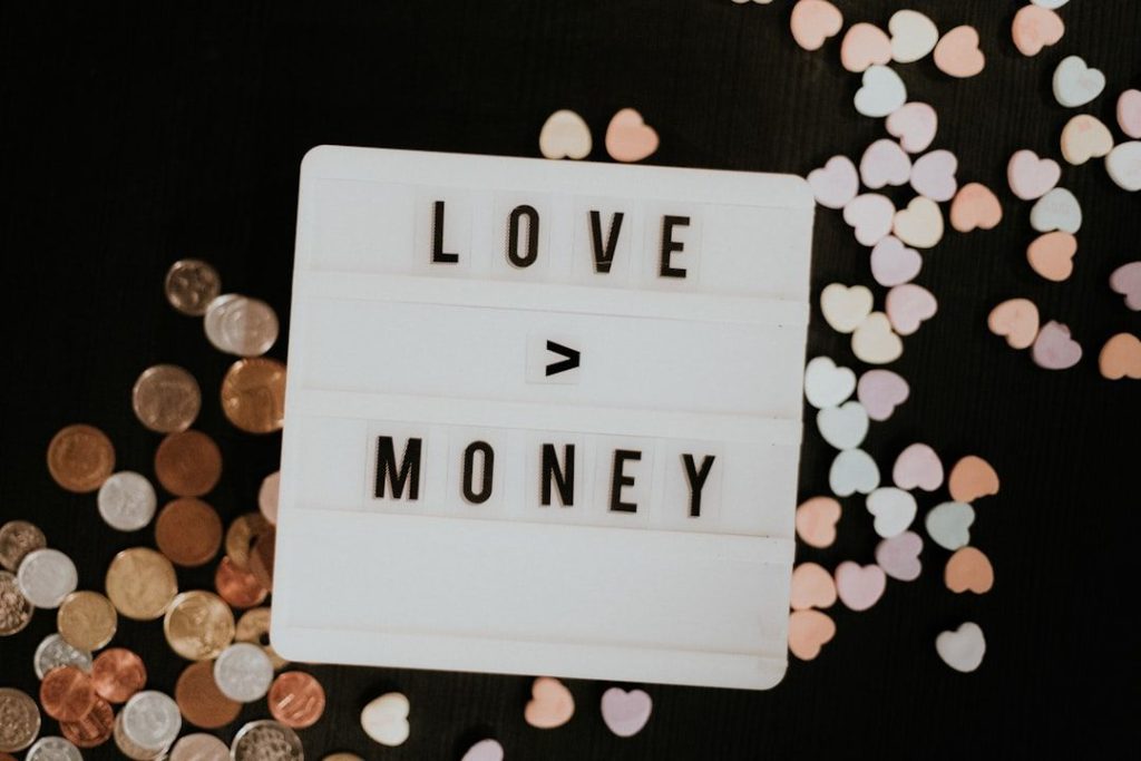 A sign saying "love money" representing a payment for an individual Shareholder Salary vs PAYE
